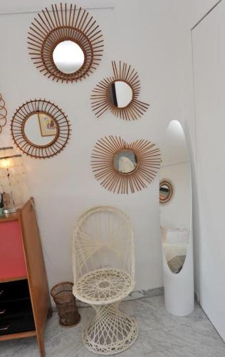 Cette chambre comprend des miroirs, une chaise blanche et un miroir. dans l'établissement Soleil et serenite au Cap Brun Toulon, à Toulon