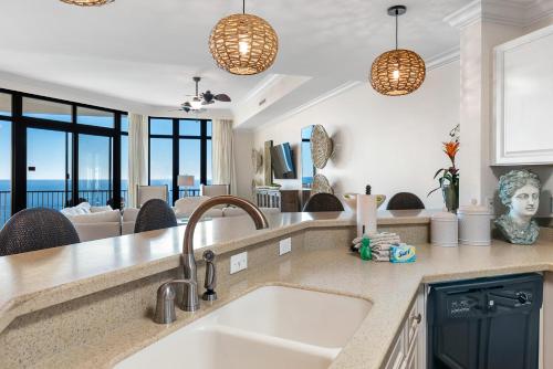 a kitchen with a sink and a living room at Phoenix West 2005 in Orange Beach