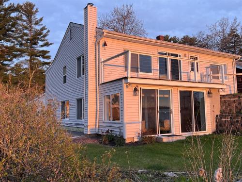 a house with a large window on the side of it at GRANDVIEW LAKEFRONT LIMIT 9 villa in North Sebago