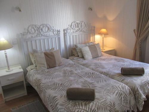 a bedroom with two beds and two lamps at Point Village Accommodation - Hemel op Aarde in Mossel Bay