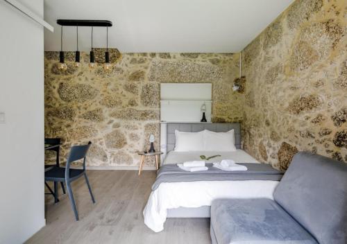 a bedroom with a bed and a couch at Quinta do Bairro in Vieira do Minho