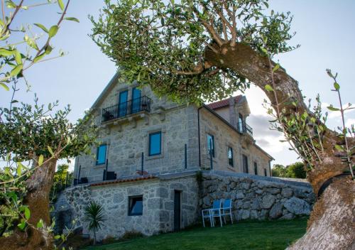 an old stone house with a stone wall at Quinta do Bairro in Vieira do Minho