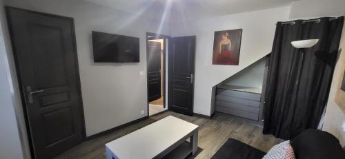 a small living room with a mirror and a door at le palierou in Paulhe