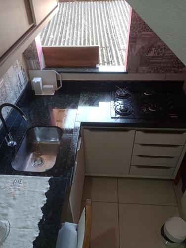 a small kitchen with a sink and a stove at CASA DA NATY in Morro de São Paulo