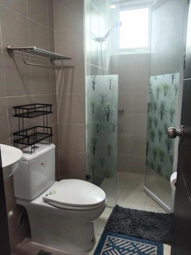 a bathroom with a toilet and a shower at Cozy, spacious and well lighted condo in Iloilo City