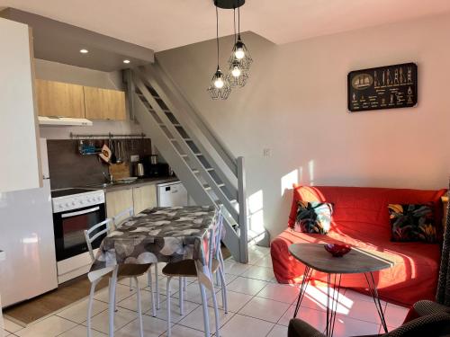 un salon avec un canapé rouge et une table dans l'établissement APPT 4P - Manoirs 1 à la Mer Chez Claudette & Marc, à Courseulles-sur-Mer