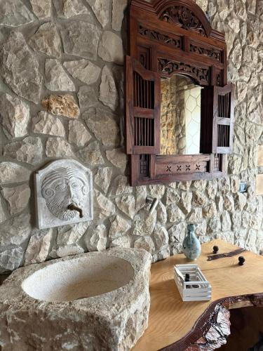 a stone bathroom with a sink and a mirror at Gesualdo Suites in Gesualdo