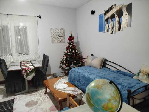 a living room with a christmas tree and a bed at Kostis Hause in Kastrákion
