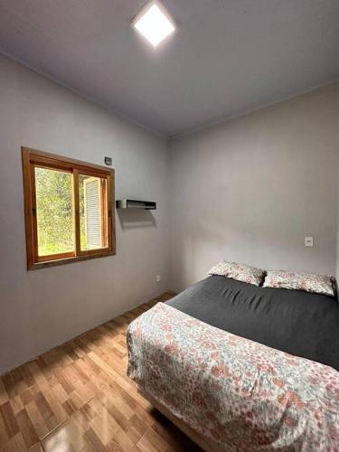 a bedroom with two beds and a window at Casa na beira do rio com Lareira in Itati