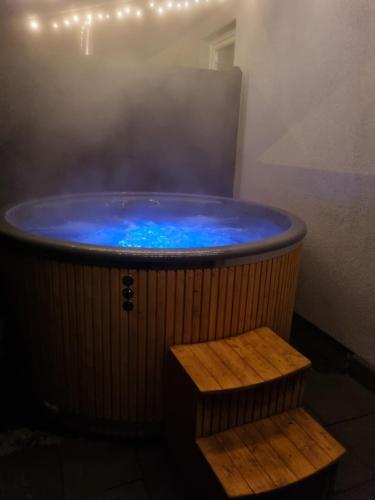 a hot tub with blue water and a wooden bench at Apartament exclusive Głuszyca in Głuszyca