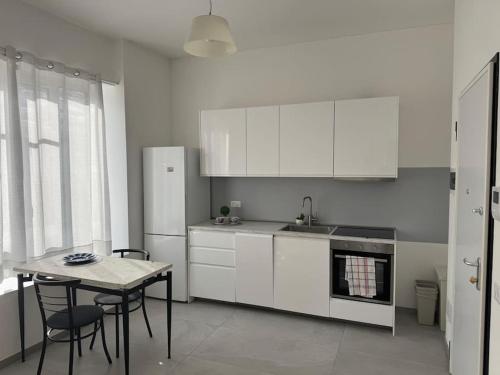 a kitchen with white cabinets and a table and a sink at Baroni B - FREE private parking-wi- fi and A-C in Milan