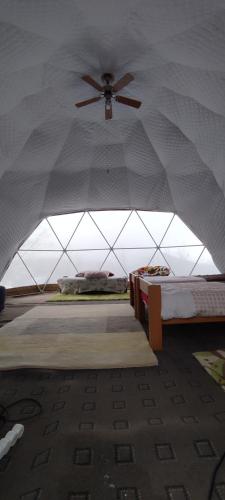a tent with two beds and a ceiling fan at Dome home tent Povlen in Taor