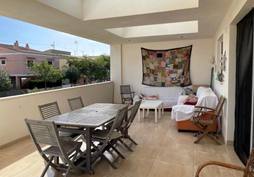 Un balcón con una mesa y sillas y un sofá. en La casa del viajero junto al mar, en Barrio-Mar
