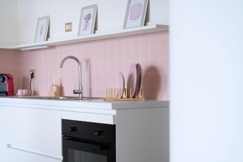 a kitchen with a sink and pink tiles at Casa Vacanze Maddalena - Palazzetto sul lago - Diamante Rosa in Marta