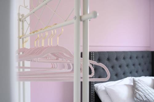 a rack with pink shirts on it next to a bed at Casa Vacanze Maddalena - Palazzetto sul lago - Diamante Rosa in Marta