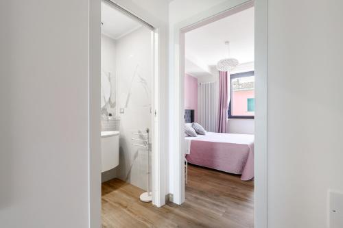 a bedroom with a bed and a tub and a sink at Casa Vacanze Maddalena - Palazzetto sul lago - Diamante Rosa in Marta