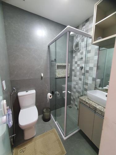 ein Badezimmer mit Dusche, Toilette und Waschbecken in der Unterkunft Casa Colorida em Touros in Touros