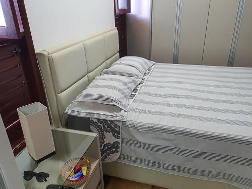 ein Bett in einem kleinen Zimmer mit einem Glastisch in der Unterkunft Casa Colorida em Touros in Touros