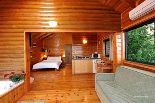 a room with a bed and a kitchen in a cabin at לוין נוף מרהיב in Amirim