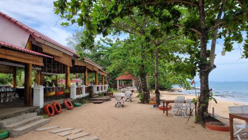 a resort with chairs and tables on the beach at Vung Bau Resort in Phú Quốc