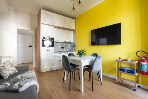 a living room with a table and a yellow wall at Sendy Home Roccaraso 3 in Roccaraso