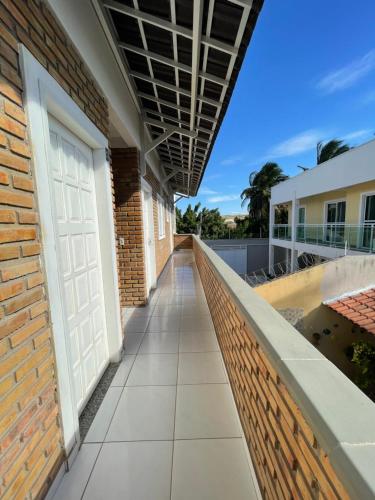a hallway of a building with a white door at Condomínio Chalés Santo Antônio - Flecheiras in Trairi