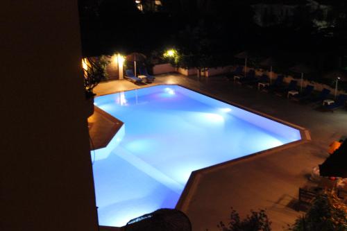 a swimming pool at night with lights in it at Tunacan Hotel in Oludeniz