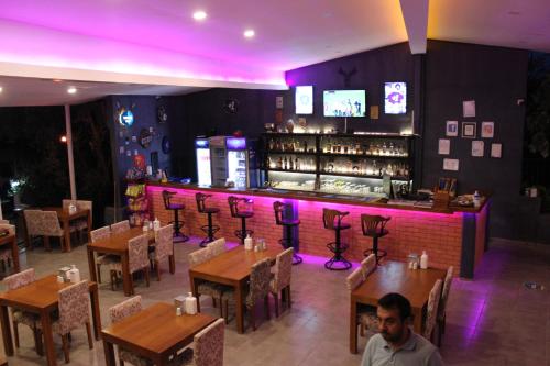 a man sitting at a restaurant with purple lighting at Tunacan Hotel in Oludeniz