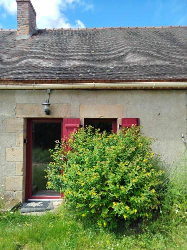 a house with a red door and a bush at Gîte des Fours in Agonges