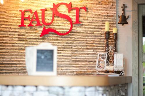 a sign on a brick wall with a candle at Apartamenty Faust in Ełk