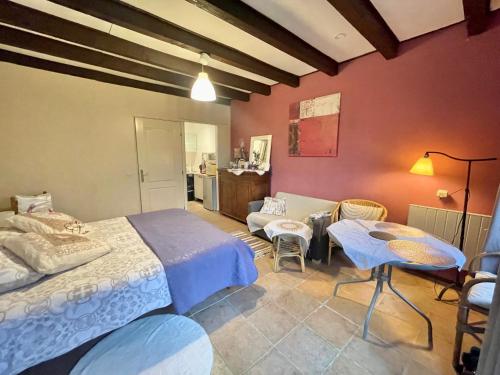 a bedroom with a bed and a table and chairs at Gîte des Fours in Agonges