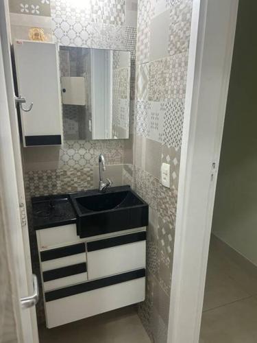 a small bathroom with a sink and a mirror at Condominio Baleares,Marina Porto Itacuruca in Mangaratiba