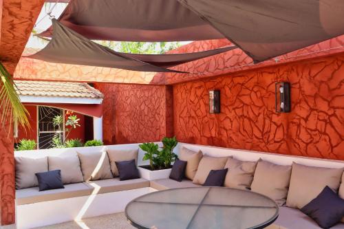 a patio with a white couch and a glass table at Keur Noel in Ngaparou