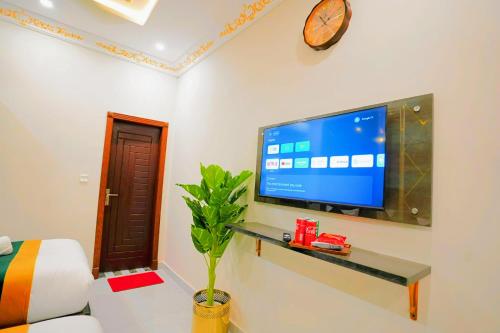 a living room with a flat screen tv on a wall at The Lahore Guest House in Lahore
