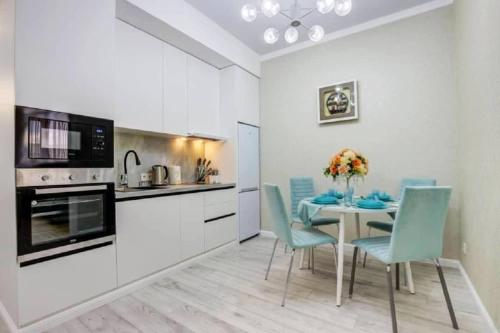 a kitchen and dining room with a table and chairs at Coco Chanel Apartment in Bishkek in Bishkek