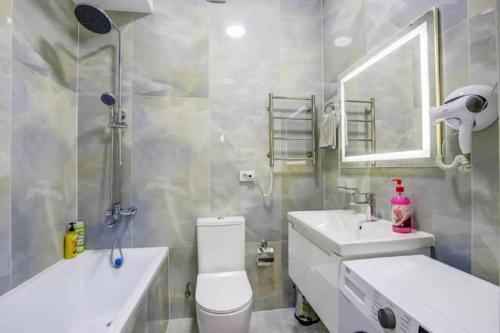 a bathroom with a toilet and a sink and a mirror at Coco Chanel Apartment in Bishkek in Bishkek