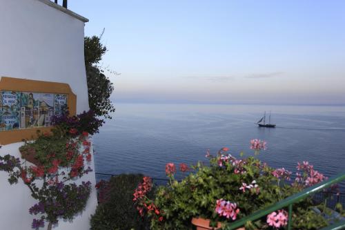 a boat in the water with flowers on a balcony at Hotel Il Nido in Amalfi
