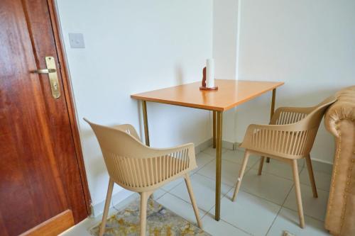 a table with two chairs and a table with a candle on it at Buxton Point by Neema Havens 2 & 3 Bedroom in Mombasa