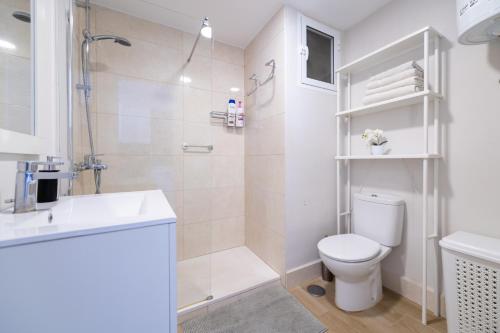 a white bathroom with a toilet and a shower at 1st line Paseo marítimo en el puerto deportivo de Marbella in Marbella