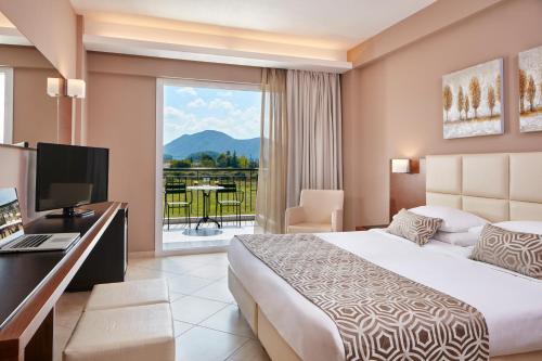 a hotel room with a bed and a desk and a window at Aar Hotel & Spa Ioannina in Ioannina