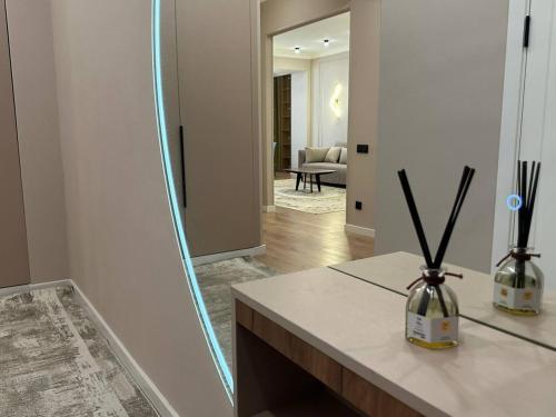 a mirror in a room with a counter and a living room at Coco Chanel Apartment in Bishkek in Bishkek