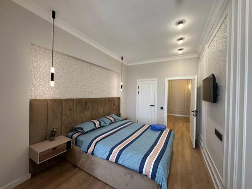 a bedroom with a large bed and a television at Coco Chanel Apartment in Bishkek in Bishkek