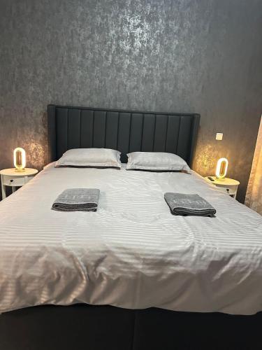 a large bed with two towels on top of it at Alex Mnl Lux Apartment free parking D12 in Bucharest