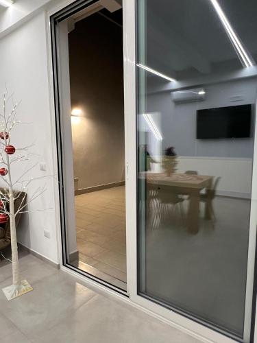 a sliding glass door leading into a room with a table at San Vito Apartment in Palo del Colle