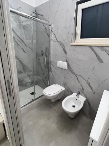 a bathroom with a shower and a toilet and a sink at San Vito Apartment in Palo del Colle