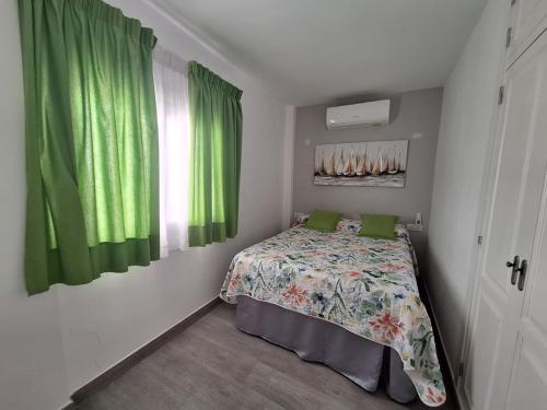 a bedroom with a bed and a window with green curtains at Adeje Deluxe Villas Santa Mónica in Adeje