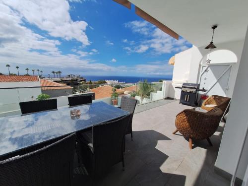 a patio with a table and chairs and a view of the ocean at Adeje Deluxe Villas Santa Mónica in Adeje