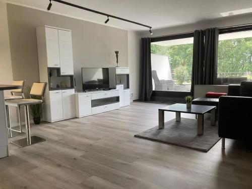 a living room with a couch and a tv and a table at Panorama Eifel View in Nideggen