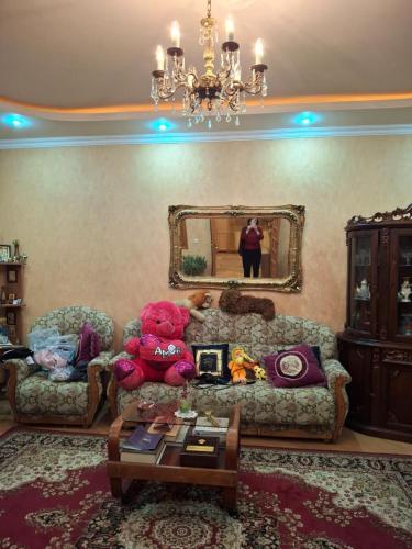 a living room with a couch and a mirror at Bubu in Tsqnetʼi