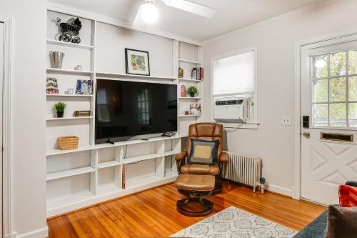 a living room with a flat screen tv and a chair at Walk Downtown Takoma Park Escape with Large Yard! in Takoma Park